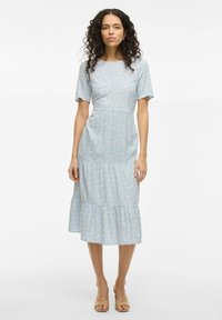 Robe florale bleu clair avec des manches courtes, un corsage ajusté et une jupe à volants. Texture de tissu doux avec un motif subtil tout au long.