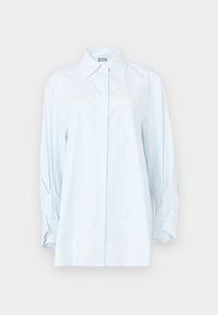 Jasnoniebieska koszula w paski na guziki z kołnierzem typu rozłożystego, długimi rękawami i luźnym krojem. Posiada kieszeń na lewej piersi oraz miękką fakturę tkaniny.