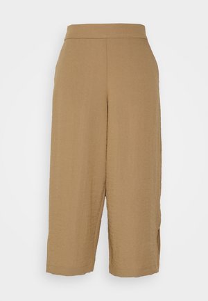 Pantalon marron à jambes larges avec une texture lisse et des fentes latérales. Il présente une taille haute et une longueur raccourcie, fabriqué en matériau léger.