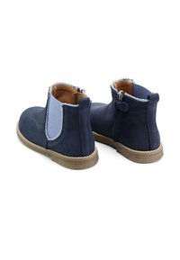 Botines azul marino de ante suave con un acento azul claro, punta redonda, una cremallera lateral y una suela de goma texturizada.