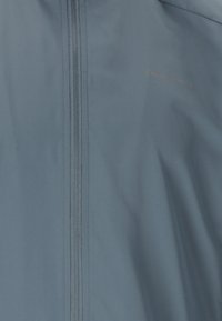 Hellblaue Jacke mit vertikalem Reißverschluss und "ENDURANCE"-Logo auf der oberen rechten Brustseite.