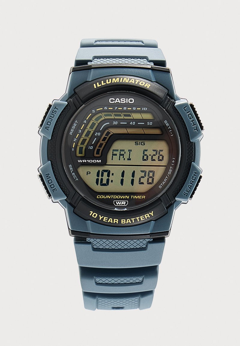Montre-bracelet numérique Casio avec bracelet bleu, affichant l'heure 10:11:28, date vendredi 26-6, minuterie de compte à rebours, et étiquette de pile de 10 ans.