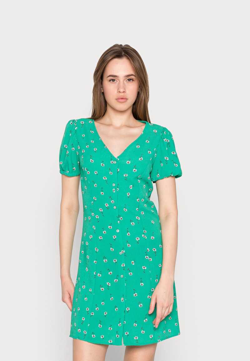 Vestido curto verde com mangas bufantes, decote em V, padrão floral e fecho de botão. Feito de tecido leve.