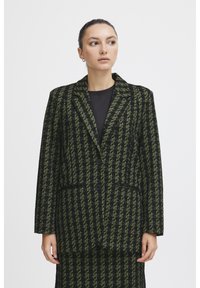 Černý a zelený houndstooth blazer s dvěma knoflíky, klopovým límcem a předními kapsami. Texturovaná tkanina, střih přizpůsobený postavě.