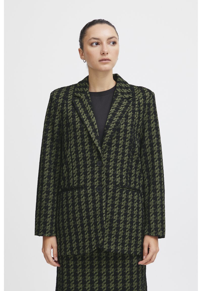 Černý a zelený houndstooth blazer s dvěma knoflíky, klopovým límcem a předními kapsami. Texturovaná tkanina, střih přizpůsobený postavě.