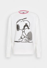 Sudadera blanca con un dibujo en línea negra de un perro de dibujos animados con un bigote, sosteniendo una raqueta de tenis, y con un cuello rojo.