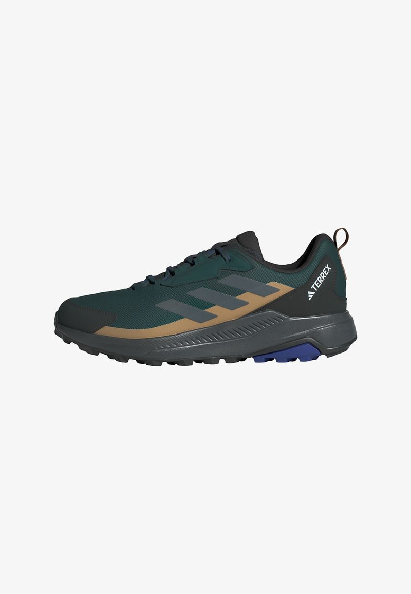 Trail running shoe in dark green mesh with black accents, tan stripes, and grey outsole. Features sturdy outsole and heel pull tab.