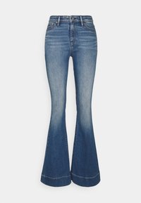 Uppfällda jeans i medelblå tvätt, med hög midja och vida ben. Slät yta med en subtil blekning och sömdetaljer vid fållen.