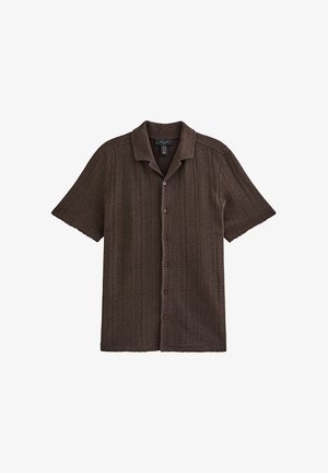 Camiseta marrón de manga corta de punto con costillas verticales, cierre frontal con botones y cuello clásico, colocada plana sobre un fondo blanco.