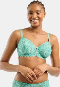 Reggiseno in pizzo teal con motivo floreale, bordi scallop e chiusura anteriore con dettagli incrociati. Spalline regolabili per una vestibilità ottimale.