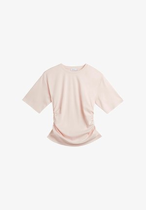 Lyserød kortærmet T-shirt med rund hals og let rynkning i siderne, lagt fladt på en hvid baggrund.