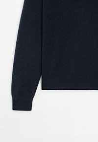 Pull tricot bleu marine, avec poignets et ourlet côtelés, texture lisse et coupe décontractée. Le tissu semble doux avec un léger éclat.