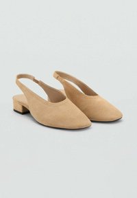 Beige suede slingback shoes with a pointed toe, low block heel, and open back design. Smooth texture with minimal stitching details.