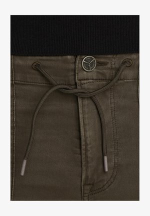 Pantalones de algodón verde oliva con cintura ajustable, que presentan un botón de metal con marca y una textura sutil en la tela.