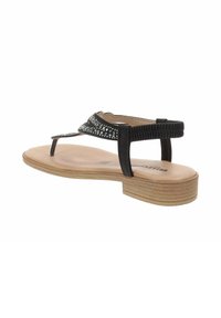 Sandalia negra con una correa texturizada adornada con piedras de strass, suela plana y un tacón con aspecto de madera. Diseño minimalista, estilo de dedo con soporte en la parte posterior.