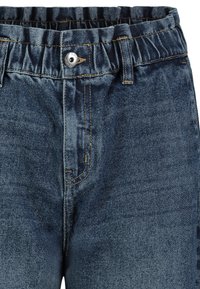 Denim jeans with a dark blue wash, elastic waistband, metal button, and visible stitching details, featuring a classic five-pocket design.