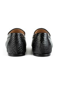 Zwarte leren schoenen met een gestructureerd, slangenhuidpatroon, ronde achterkant en een lage zwarte zool. Gladde binnenvoering zichtbaar.