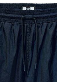 Navy blue drawstring shorts with an elastic waistband, made from lightweight fabric, featuring a smooth texture and minimal design details.