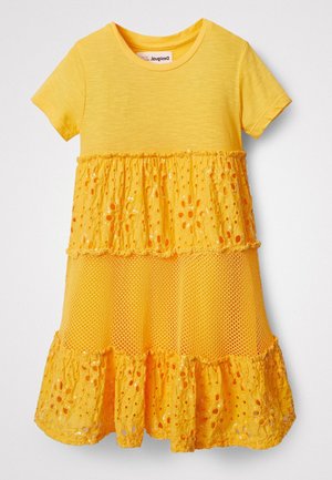 Vestido amarillo de manga corta con falda de volantes que presenta detalles de encaje, malla y lentejuelas, diseñado para un niño.