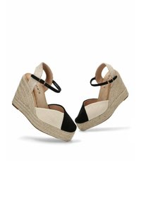 Sandalias de cuña con suela de yute que presentan paneles de tela negra y beige, tira en el tobillo y acentos de algodón texturizado.