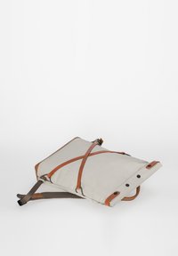 Hellgrauer Rucksack aus strapazierfähigem Material, akzentuiert mit braunen Lederträgern und -beschlägen. Verfügt über ein minimalistisches Design und einen Crossbody-Stil.