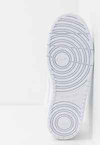 Vit Nike sneakersula med cirkulära mönster, texturerad yta och tryckt "ALL DAY PLAY". Slät, icke-märkande material.