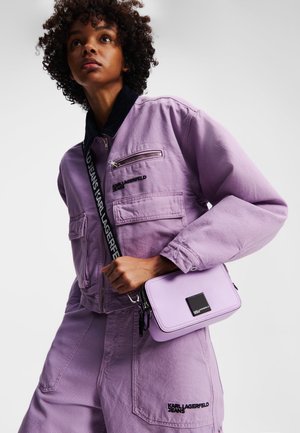 Lilac jacket with black collar and zippered pocket, paired with a matching lilac crossbody bag featuring a square accent and zip closure.