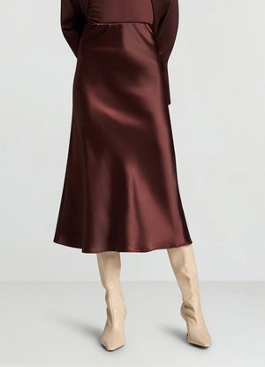 Langes braunes Satinkleid mit fließender Silhouette, glatter Textur und mittellangem Saum. Kombiniert mit beigen, figurbetonten kniehohen Stiefeln.