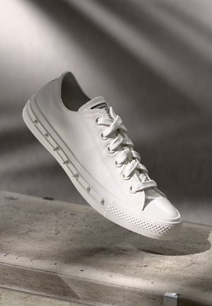 Vita canvas sneakers med gummisula, med snörning, rund tå och texturerad yttersula. Sticksömmar och logotyp på tungan.