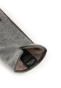 Grau gefütterter Handschuh mit einem glatten, dunkelgrauen Rand. Das Innenfutter verfügt über ein warmes, braunes Textilfutter und ein schwarzes Etikett mit Pflegeanweisungen.