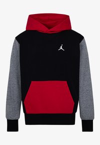 Sudadera negra con capucha roja, mangas grises y un bolsillo frontal rojo. Presenta un logo Jumpman blanco en el pecho. Textura de tela suave.