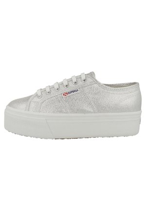 Sneakers in tela metallica argento con suola in gomma bianca a piattaforma, punta rotonda e design con cinque fori per i lacci. Presentano il logo Superga.