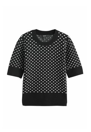 Schwarzer Strickpullover mit kurzen Ärmeln, versehen mit einem Muster aus weißen Polka-Dots. Gerippte Textur an Bündchen und Saum. Das Label trägt die Aufschrift "NEXT."