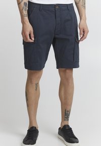 Shorts cargo marine en mélange de coton, avec des poches avant et deux poches cargo latérales. Comprend un bouton en laiton et des accents cousus.