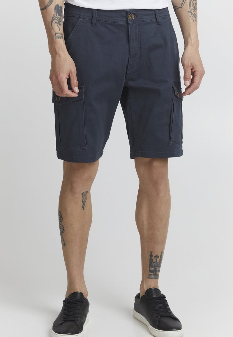Shorts cargo marine en mélange de coton, avec des poches avant et deux poches cargo latérales. Comprend un bouton en laiton et des accents cousus.