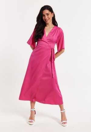 Pink satin wrap dress with short flared sleeves, a tie waist, and a mid-calf length. Features a V-neckline and subtle sheen.