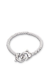 Brazalete de plata con diseño de cuentas y un cierre con dos elementos entrelazados. Textura lisa y acabado pulido.