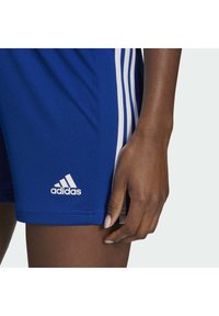 Adidas plave atletske kratke hlače izrađene od lagane tkanine, s tri bijele pruge sa strane i bijelim logotipom na rubu.