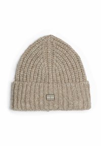 Gorro de punto beige claro con textura acanalada, puño doblado y una etiqueta rectangular con el logo "TOMMY JEANS" en la parte frontal.