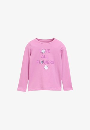Camiseta de manga larga rosa hecha de algodón, que presenta el texto "AMA TODAS LAS FLORES" y tres apliques de flores con lentejuelas.