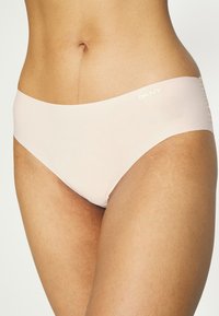 Svetlo roza DKNY hipster spodnje hlače z gladko teksturo in širokim pasom. Imajo diskretno belo logotip na strani.