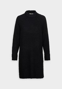 Robe pull noire en tricot avec un col haut, des poignets côtelés et un tissu texturé, présentant une coupe décontractée et des fentes sur les côtés.