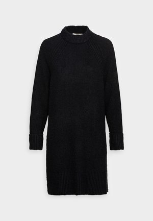Robe pull noire en tricot avec un col haut, des poignets côtelés et un tissu texturé, présentant une coupe décontractée et des fentes sur les côtés.