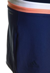 Bermudas marinas de tejido que absorbe la humedad, con una cinturilla elástica que presenta acentos en blanco y coral, tejido texturizado y un logo en relieve.