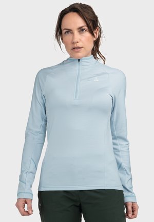 Helles blaues Langarmhemd mit einem Viertel-Reißverschluss-Kragen und strukturiertem Stoff. Weist ein Logo auf der Brust und Daumenlöcher an den Bündchen auf.