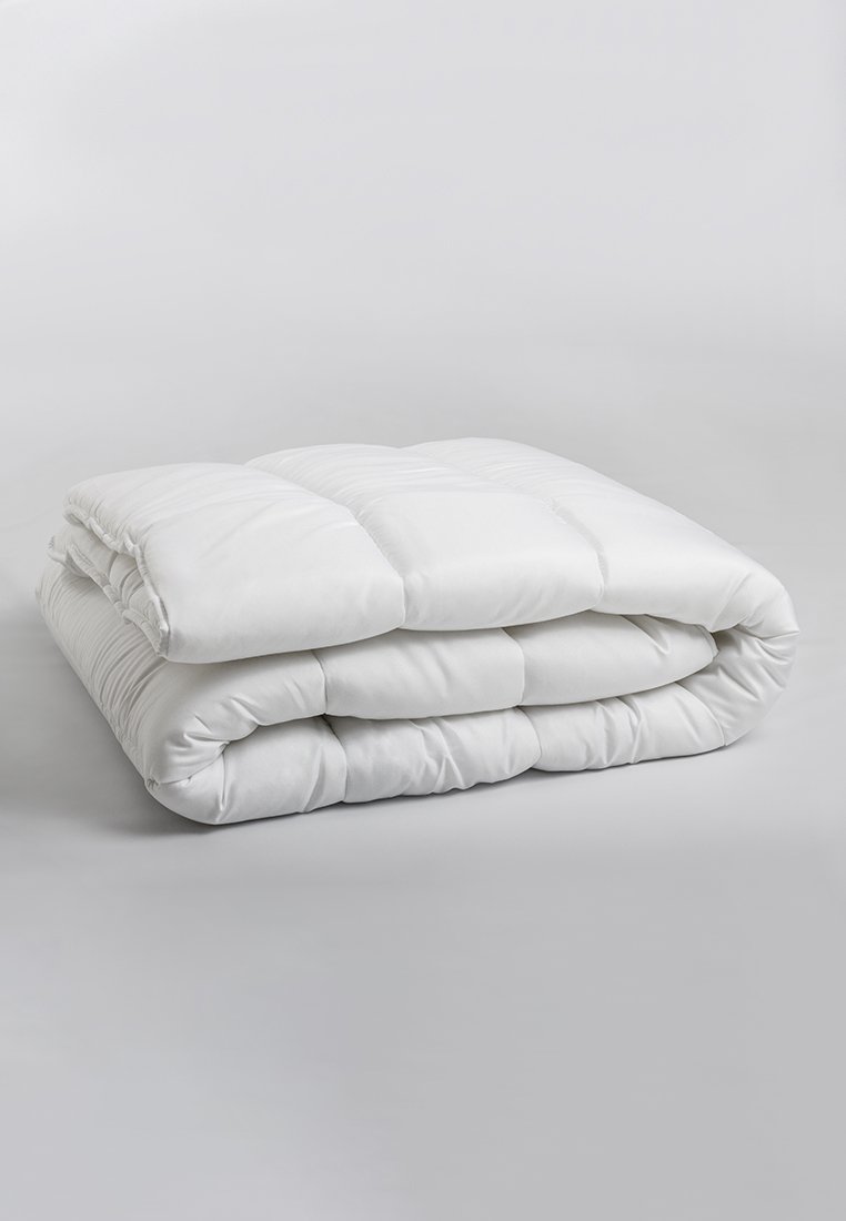 Edredón blanco acolchado doblado en forma rectangular, con una textura suave y patrones uniformemente cosidos, sobre un fondo neutro.