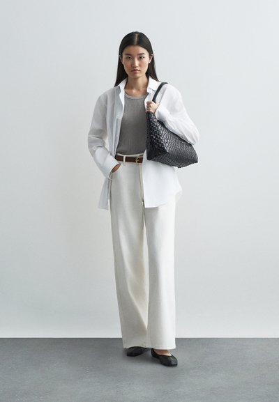 White button-up shirt, gray ribbed tank top, white wide-leg trousers, black woven bag, black flats. Smooth fabric, relaxed fit, minimal design.
