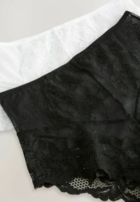 Deux bralettes en dentelle : l'une noire avec des motifs floraux et des détails en maille, l'autre blanche avec des bords en dentelle complexe. Tissu doux et extensible.