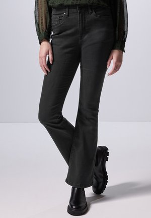 Zwarte flared jeans met een mid-rise taille, voorzien van twee vo pocketen en een gladde denim textuur. Gecombineerd met zwarte enkellaarsjes.