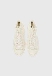 Hvit høytopp sneakers laget av teksturert stoff med blomstermønster, flate lisser og gummitåhette. Glatt såle med subtile detaljer.